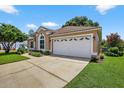 Exterior shot of a two-car garage with white door, set against a blue sky backdrop at 11550 Wellman Dr, Riverview, FL 33578
