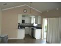 Open concept kitchen with white cabinets, stainless steel appliances, and sliding glass doors at 13627 San Rafael Dr, Largo, FL 33774