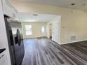 Open-concept living area with durable wood-look floors, stainless steel fridge and access to the front door at 1557 S Martin Luther King Jr Ave, Clearwater, FL 33756