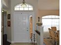 Bright entryway with a white front door, transom window, and view into the dining room at 3212 Stevenson St, Plant City, FL 33566