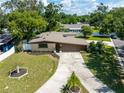Exterior view of home with a long drive and mature trees and shrubs at 4018 E Bluff Ave, Tampa, FL 33617