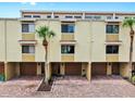 Bright townhouse complex showcasing garages and brick driveways, enhanced by palm trees for classic Florida charm at 459 Haven Point Dr, Treasure Island, FL 33706