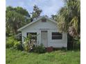 Charming single-story home nestled amongst tropical foliage, displaying a quaint exterior with bright white siding at 518 Woodlawn St, Clearwater, FL 33756