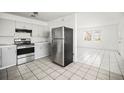 Kitchen with light gray cabinets, tile backsplash, stainless steel appliances and tile floors at 551 Bay St, Dunedin, FL 34698