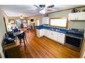 Bright and open kitchen featuring white cabinets, stainless steel appliances, and wood floors at 5812 Montana Ave, New Port Richey, FL 34652