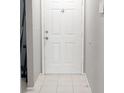 A white front door sits in front of an entryway with tile flooring at 7148 E Bank Dr # 7148, Tampa, FL 33617
