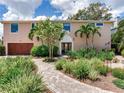 Beautiful two story home with mature landscaping and a brick walkway at 8 Sunset Bay Dr, Belleair, FL 33756