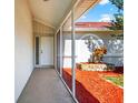 Screened entry porch with red mulch landscaping at 8005 Pepperidge Ln, Port Richey, FL 34668