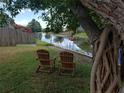Tranquil backyard with waterfront views, featuring inviting Adirondack chairs for relaxation at 10160 118Th Ave, Largo, FL 33773