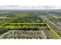 Aerial view of land for sale between neighborhood and wooded area with a yellow rectangular border at 11109 Sumner Rd, Wimauma, FL 33598