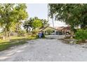 View of the front exterior showing the entrance gate, yard and side of the house at 11109 Sumner Rd, Wimauma, FL 33598