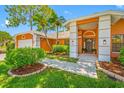 Beautiful front yard with lush landscaping, a well-maintained lawn, and a welcoming entrance at 1111 Chatham Ct, Safety Harbor, FL 34695
