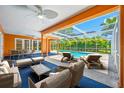 Relaxing outdoor patio with comfortable seating, overlooking a sparkling screened-in pool and lush greenery at 1111 Chatham Ct, Safety Harbor, FL 34695