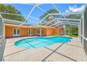 Sparkling in-ground pool surrounded by a screened enclosure, perfect for enjoying the outdoors in privacy at 1111 Chatham Ct, Safety Harbor, FL 34695