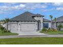 Charming home with a three-car garage, and manicured lawn, set against a backdrop of blue skies and fluffy clouds at 11324 Striped Bass Ct, New Port Richey, FL 34654