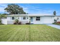 Charming single-story home with a well-manicured lawn, blue shutters, and a freshly painted exterior at 11416 126Th N Ave, Largo, FL 33778
