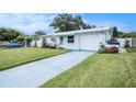Well-maintained single-story home with an attached garage and a blue driveway at 11416 126Th N Ave, Largo, FL 33778