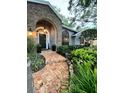 Inviting front entrance with a brick walkway, lush greenery, and stylish architectural details at 11760 Ashley Ct, Seminole, FL 33772
