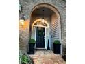 Elegant front door with brick archway, decorative wreath, and classic outdoor lighting at 11760 Ashley Ct, Seminole, FL 33772