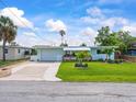 Single-story home with large lawn, landscaping, and a charming covered front porch area at 13316 Carol Dr, Hudson, FL 34667