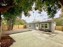 Spacious backyard featuring a concrete patio, a privacy fence, and mature landscaping at 1554 Elmwood St, Clearwater, FL 33755