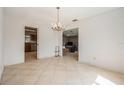 Bright dining room with tile flooring and a decorative chandelier, open to the kitchen and living areas at 15612 Farnsworth Ln, Tampa, FL 33624