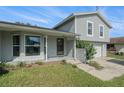 Charming two-story home with a well-maintained lawn and a brick accent wall, complemented by lush greenery at 15612 Farnsworth Ln, Tampa, FL 33624