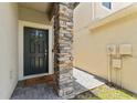 Stylish front door with stone column and a wreath, creating a welcoming entrance at 1604 Acadia Harbor Pl, Brandon, FL 33511