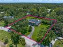 Sprawling property with a stately home, surrounded by lush greenery and mature trees, enclosed by a pink property line at 1681 Long Bow Ln, Clearwater, FL 33764