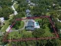 Lush property with a stately home, swimming pool, mature trees, and generous landscaping enclosed by a pink property line at 1681 Long Bow Ln, Clearwater, FL 33764
