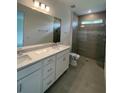 Modern bathroom featuring a double sink vanity with a glass-enclosed shower and neutral colors at 18848 Indian Rock Pl, Lakewood Ranch, FL 34211
