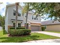 Beautiful two-story home featuring stone accents, a gray garage door, and lush green landscaping at 19309 Prairie Tree Pl, Tampa, FL 33647