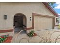 Home exterior showcasing a two-car garage, a arched entryway, and manicured landscaping at 2584 58Th S Ave, St Petersburg, FL 33710