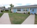 Well-maintained single-story home featuring a light blue front door and lush green lawn at 402 Dorchester Pl # 44, Sun City Center, FL 33573