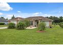 Charming single-story home with a well-manicured lawn and mature landscaping under a bright, sunny sky at 40449 Trotter Ln, Dade City, FL 33525