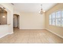 Spacious dining area with tile flooring, a chandelier, and natural light creating a welcoming atmosphere at 4760 Wheel House Dr, New Port Richey, FL 34652
