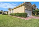 View of the side and front of the home, showing the manicured lawn and tidy landscaping around the house at 4760 Wheel House Dr, New Port Richey, FL 34652