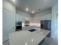 Bright kitchen with stainless steel appliances, quartz countertops, and a spacious center island at 4947 Ribbon Rock Cv, Lakewood Ranch, FL 34211