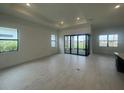 Bright, airy living room featuring large windows, recessed lighting, and sliding glass doors at 4947 Ribbon Rock Cv, Lakewood Ranch, FL 34211