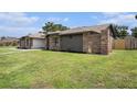 Charming exterior showcasing brickwork and updated siding, set against a lush green lawn at 513 Sportsman Park Dr, Seffner, FL 33584