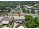 Aerial view of elevated home featuring a white exterior, with mature trees and landscaping at 6924 Americana Ne Dr # 167, St Petersburg, FL 33702