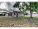 Side view of the residence showcasing the manicured lawn and the home's architectural style and white fenced back yard at 8200 Westfield Dr, Port Richey, FL 34668
