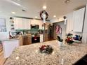 Modern kitchen with stainless steel appliances, granite countertops, and stylish pendant lighting at 8616 Pinafore Dr, New Port Richey, FL 34653
