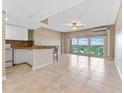 Bright living room and kitchen with tile floors, ceiling fan, and sliding glass doors to balcony at 880 Mandalay Ave # C512, Clearwater Beach, FL 33767