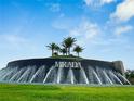 Stunning Mirada entrance featuring a cascading waterfall, lush landscaping, and palm trees at 10702 Laxer Cay Loop, San Antonio, FL 33576
