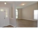 Open-concept living room featuring wood-look floors, neutral paint, and an abundance of natural light at 11227 Thicket Ct, Tampa, FL 33624