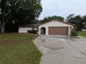 Neutral stucco single story home featuring a large driveway and an attached two car garage at 11308 Echo View Dr, Odessa, FL 33556