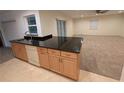 Kitchen view showcasing oak cabinets, granite countertops and an adjoining living room at 11308 Echo View Dr, Odessa, FL 33556