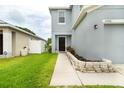 Charming home entrance featuring a walkway, dark door, rock-lined garden and green lawn at 11926 Grand Kempston Dr, Gibsonton, FL 33534