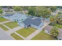 A single-story home features a big backyard, long driveway, lush landscaping, and a neutral color palette at 13916 Briardale Ln, Tampa, FL 33618
